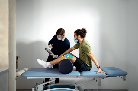 Physical Therapist Holding a Tablet with Anatomy Chart and Explaining the Problem to the Patient